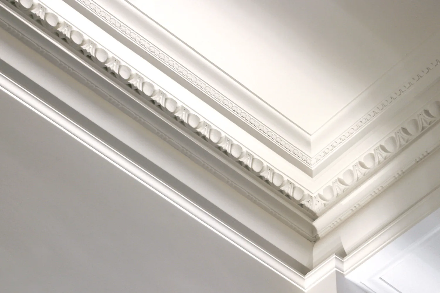 A detail of the building's plaster cornice, lit from one side.