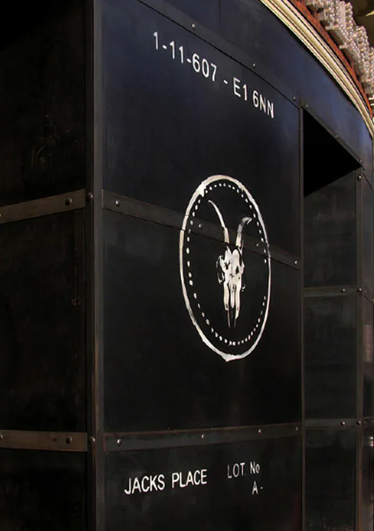 A dark signage panel carrying the AllSaints ram skull roundel.