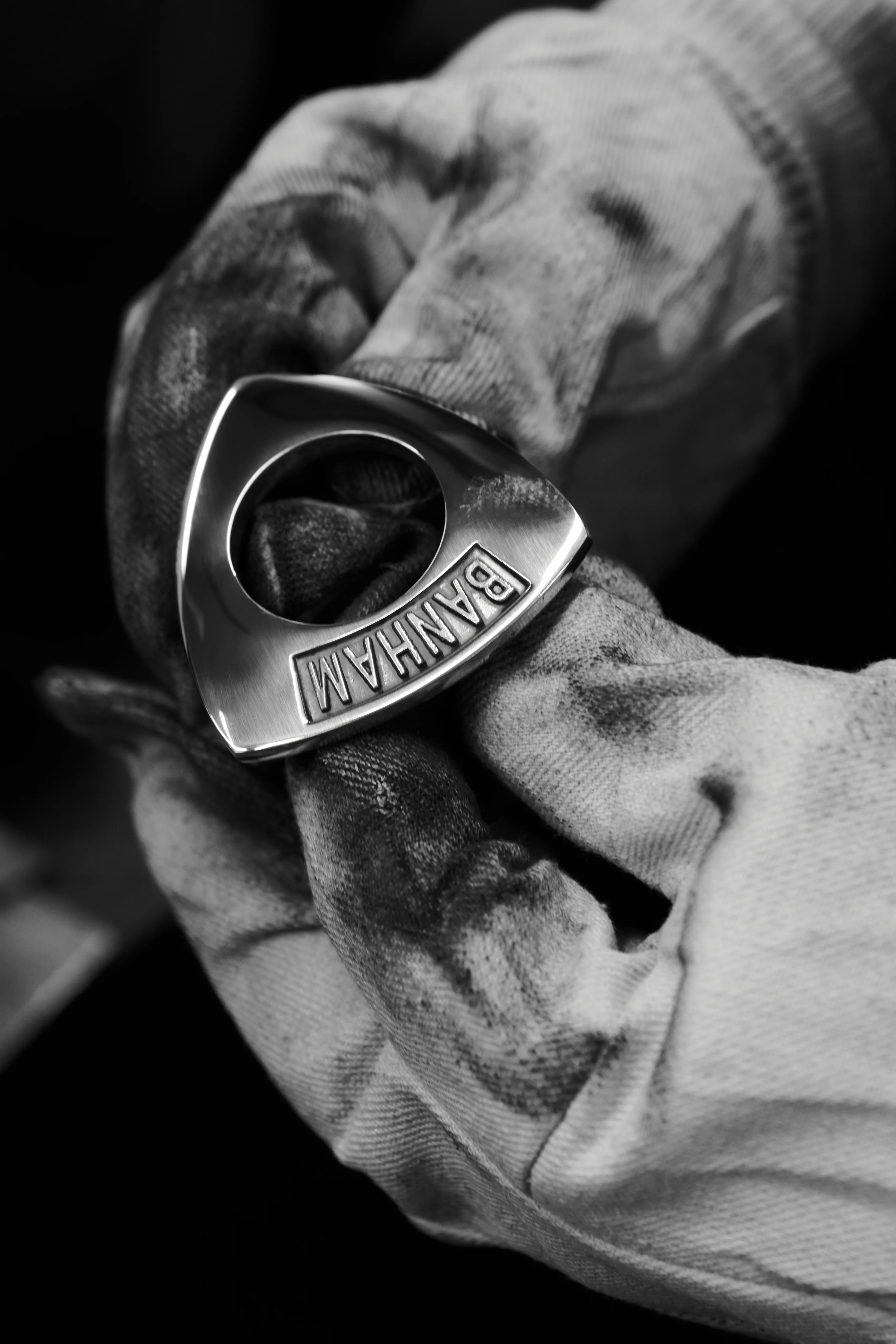 A polished Banham escutcheon held in a worn cotton work glove.