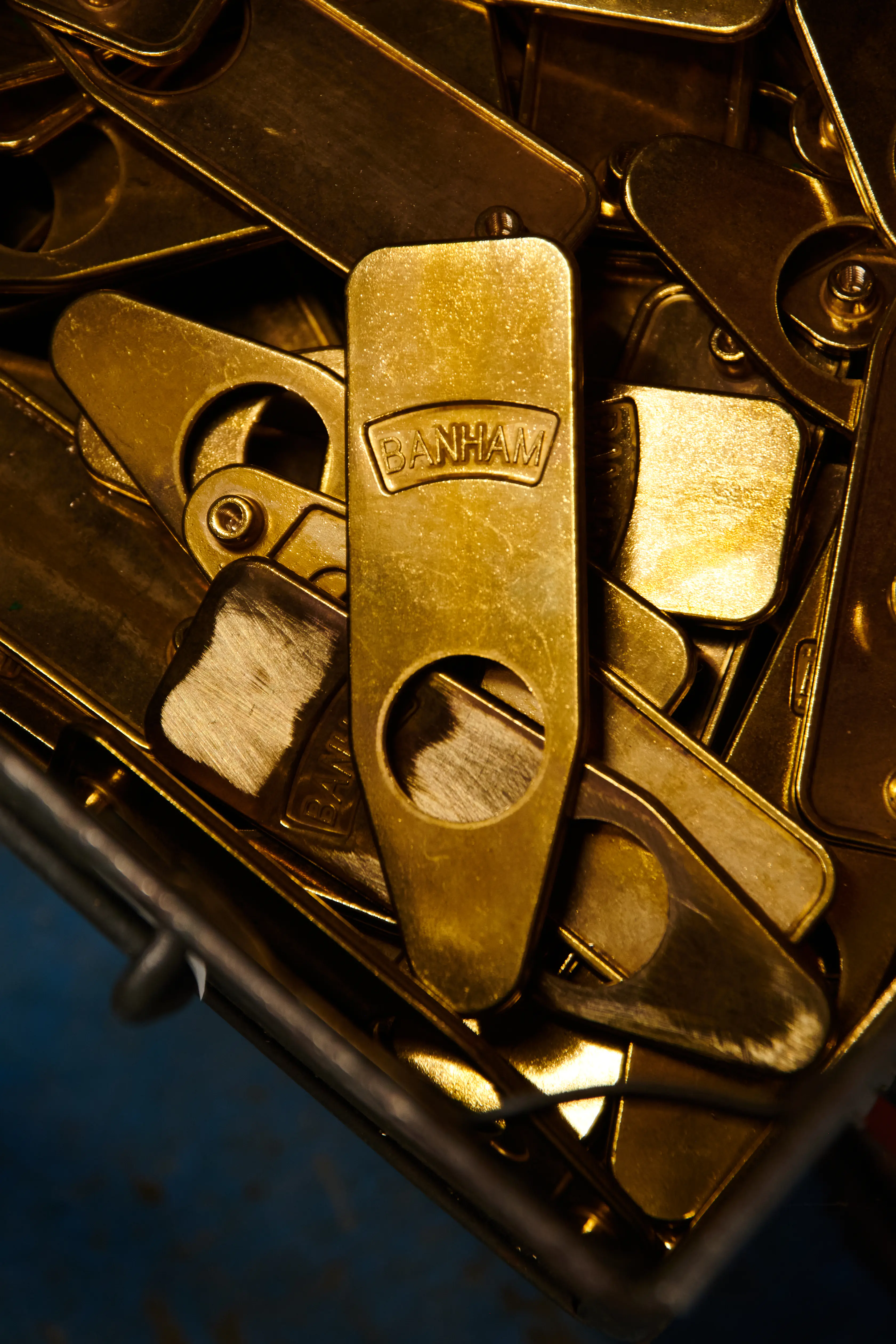 A wire tray of brass Banham escutcheon covers, the one in front raised-stamped with the Banham name.