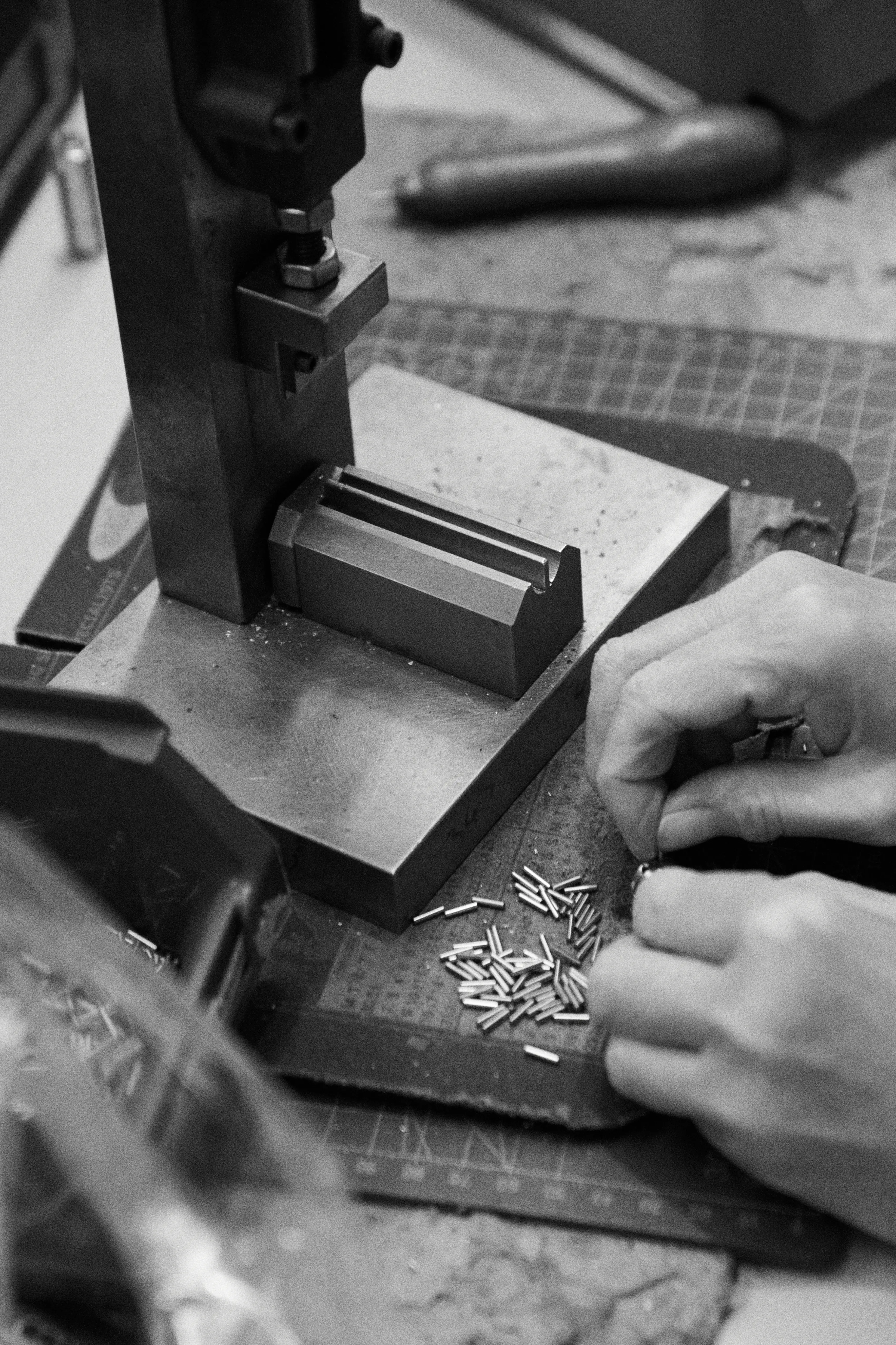 A Banham craftsperson sorting lock pins by hand at a bench press.