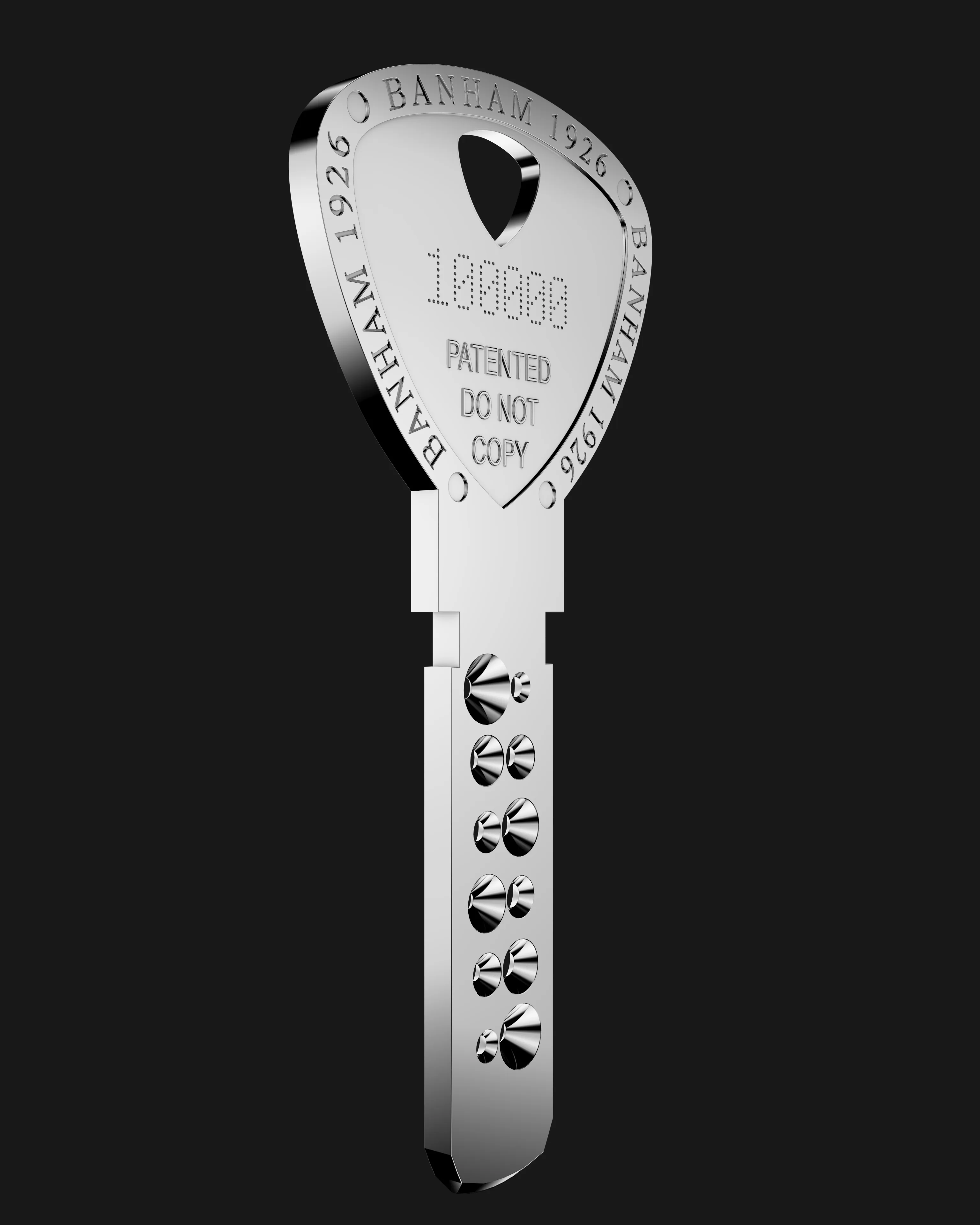 A Banham key rendered in silver against near-black, its bow engraved BANHAM 1926 around the edge and stamped PATENTED DO NOT COPY.