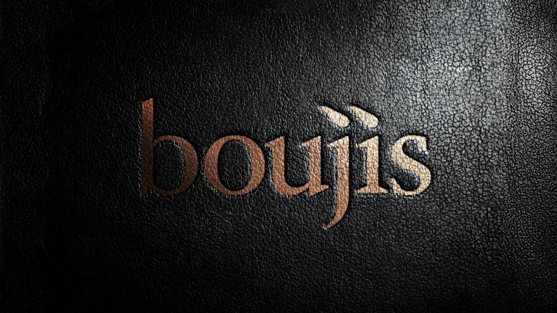 The boujis wordmark embossed in gold on black grained leather.