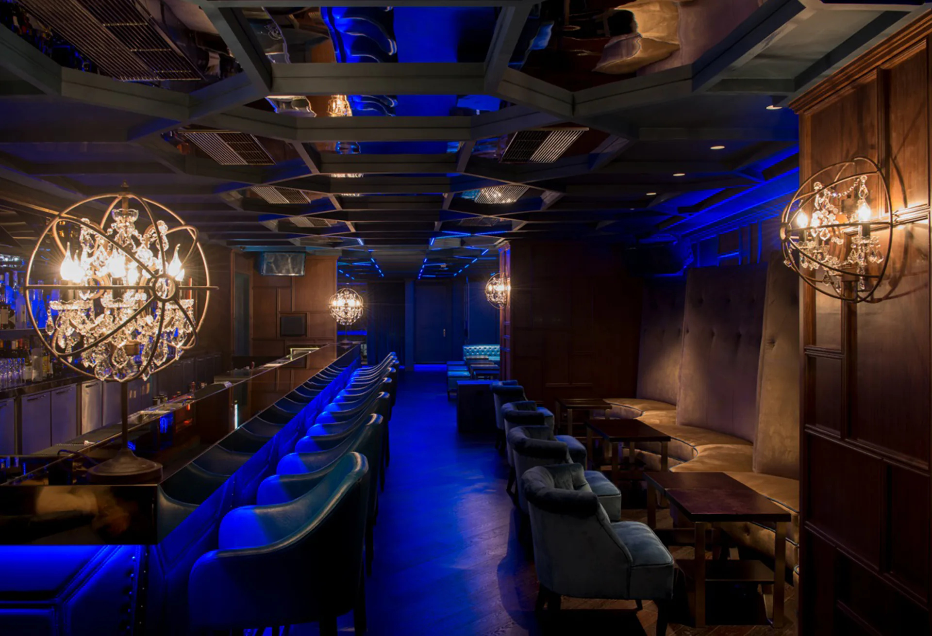 Blue-lit banquettes and globe chandeliers down the length of the room.