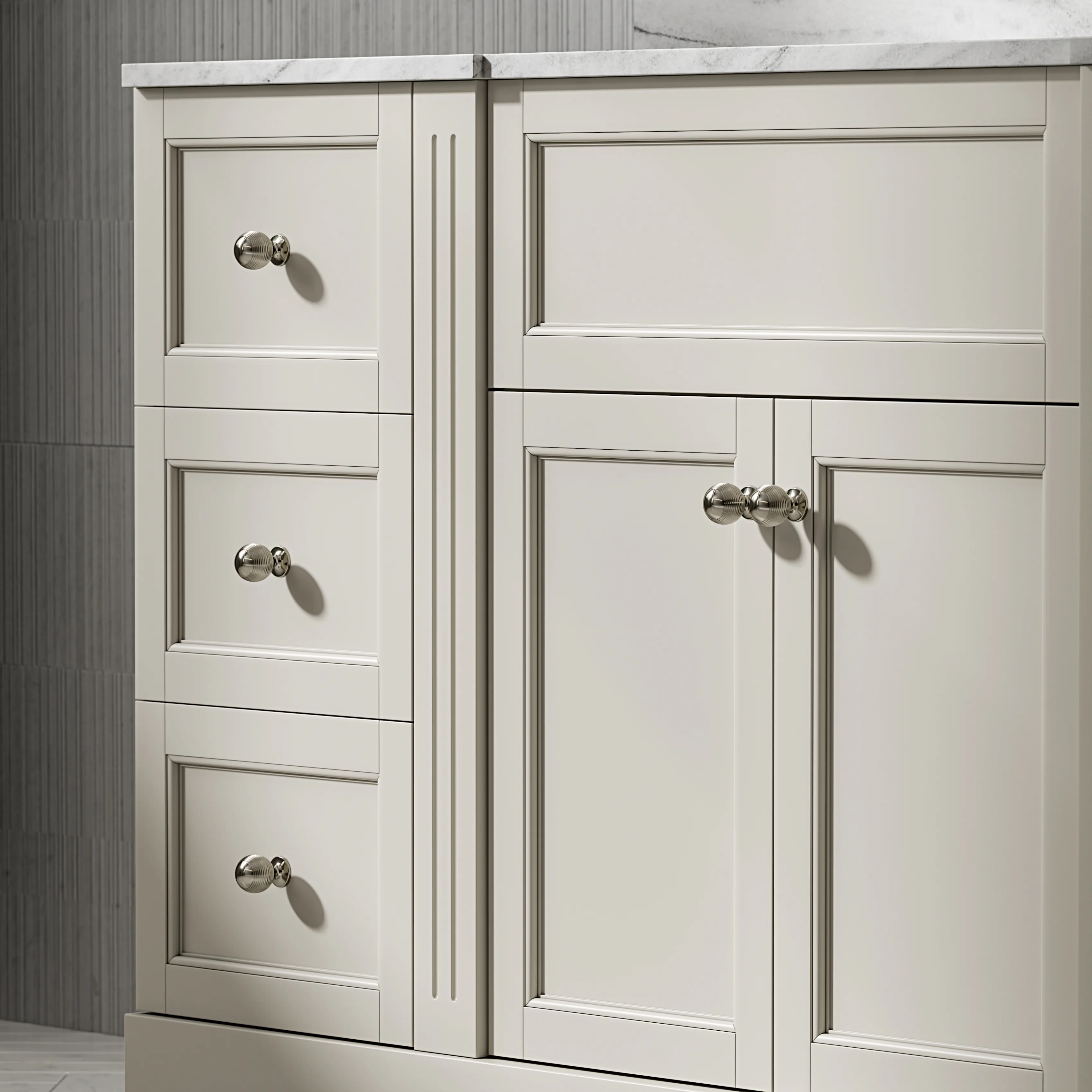 Cream vanity drawers and doors at close range, with polished nickel cup handles.