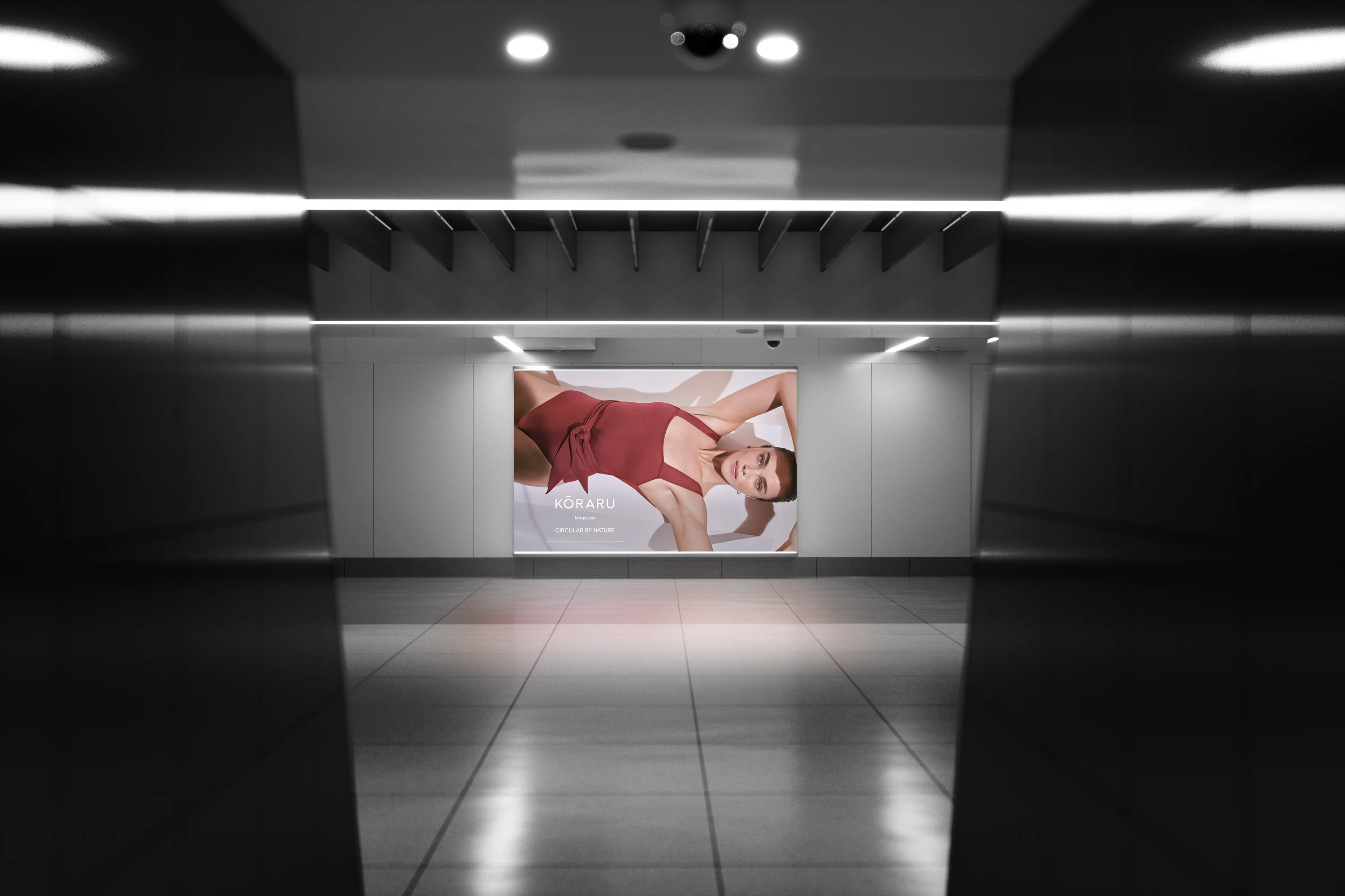 A lit Kōraru billboard at the end of a dark, mirrored hall.