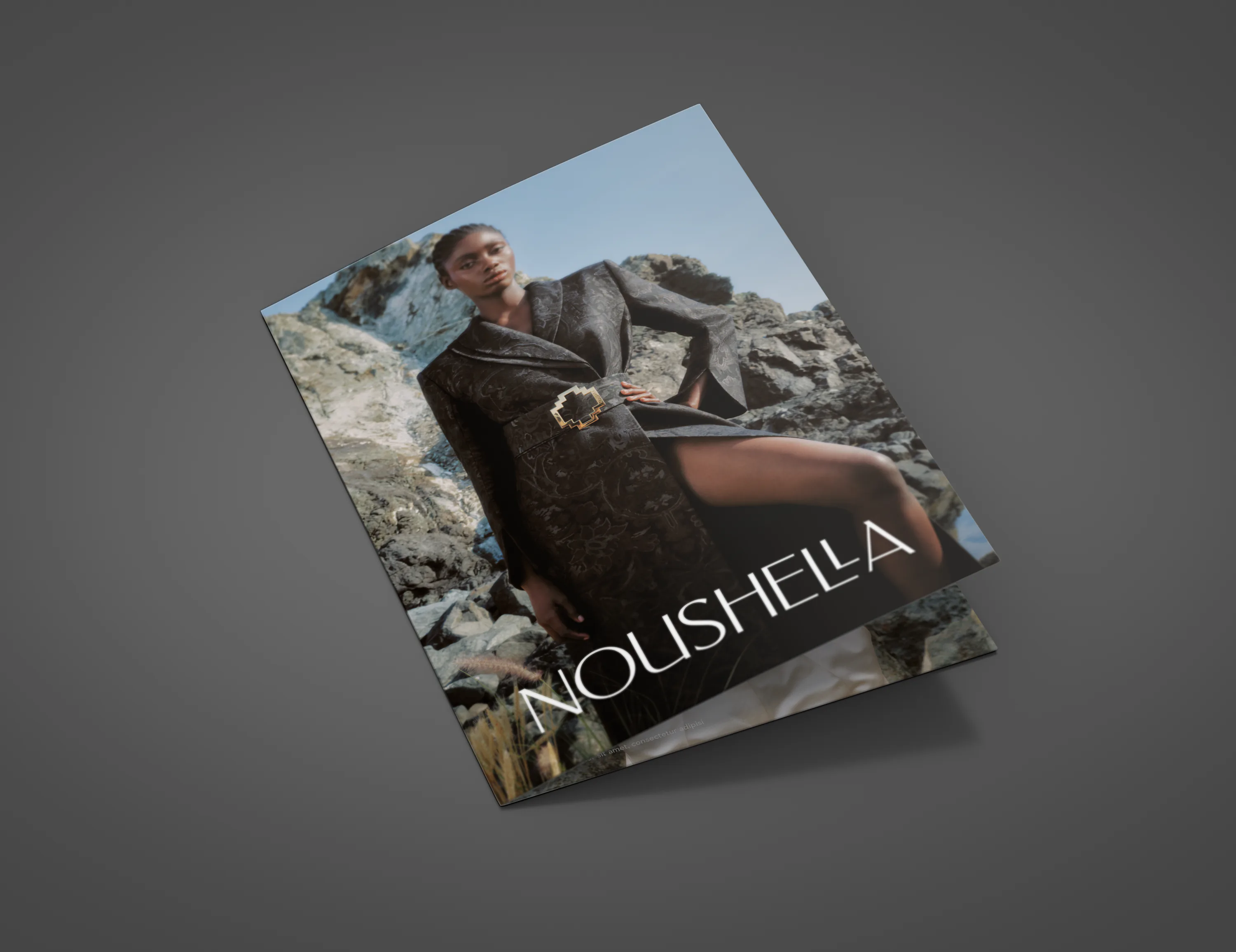 The Noushella lookbook, its cover showing a model on rocks above the sea.